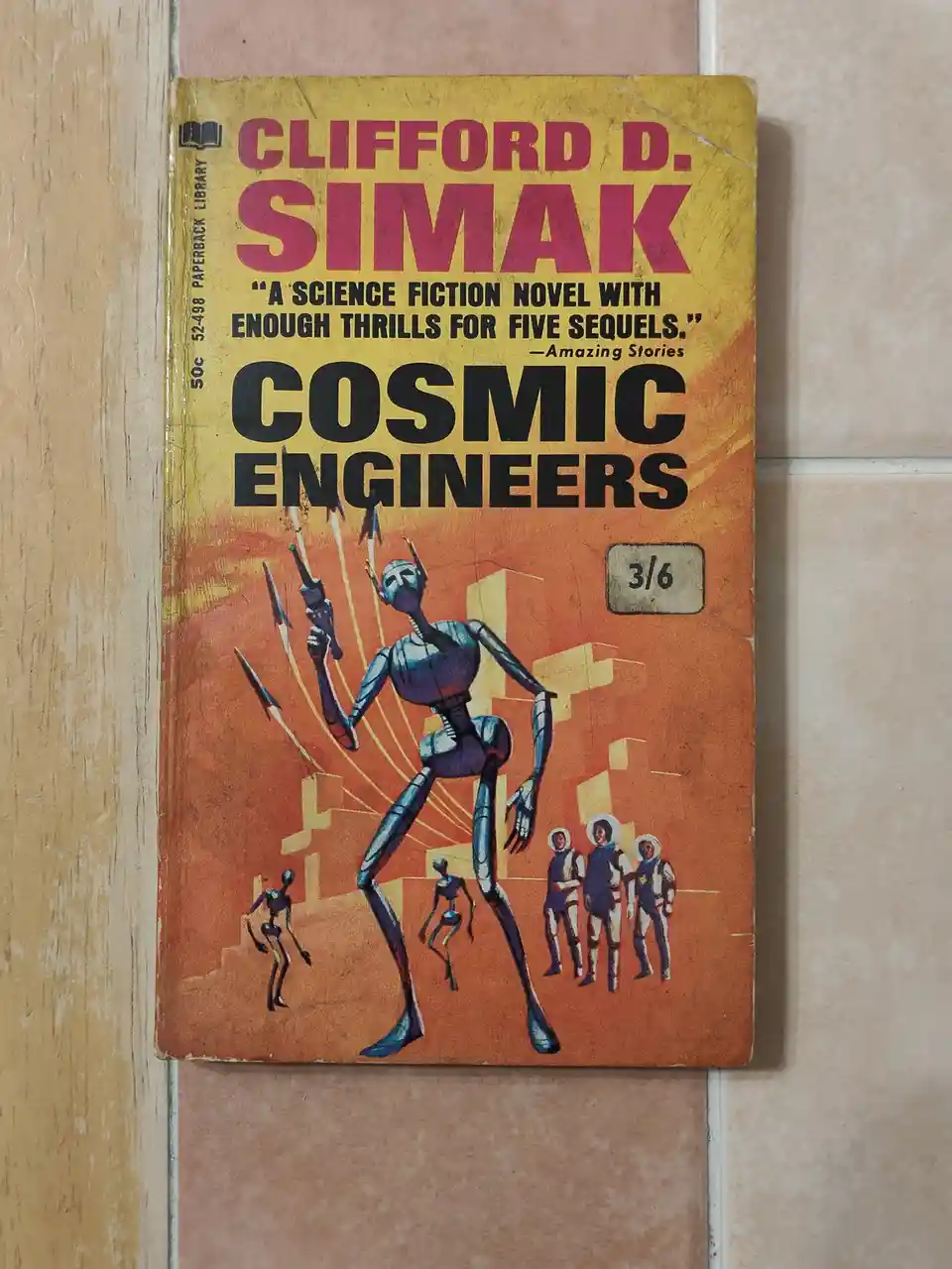A vintage paperback book titled 'Cosmic Engineers' by Clifford D. Simak, featuring a retro sci-fi cover with a large blue…