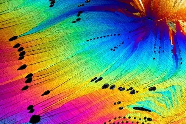 A vibrant, abstract image of a rainbow-colored surface with black footprints leading across it, overlaid with the text 'i'm…