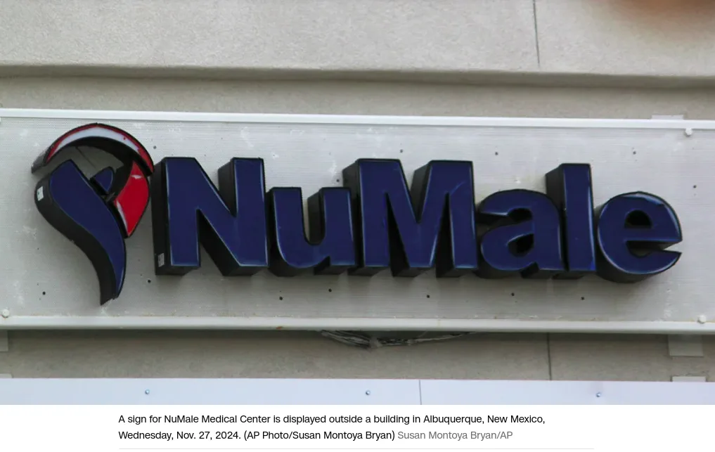 A close-up photo shows a 3D blue sign for 'NuMale Medical Center' mounted on a building facade, featuring a stylized logo…