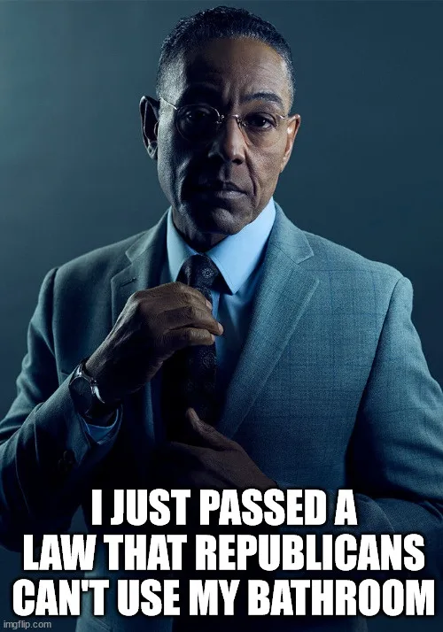 A man in a suit and glasses, adjusting his tie, looks intensely at the camera. White bold text overlaid at the bottom reads…