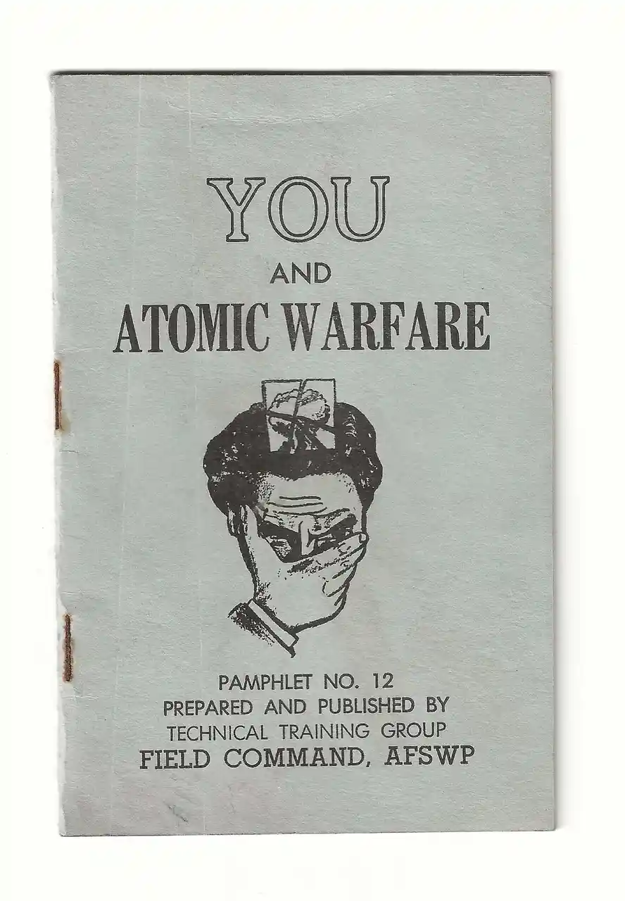 The image shows the cover of a vintage pamphlet titled 'YOU AND ATOMIC WARFARE'. It features a black-and-white illustration…