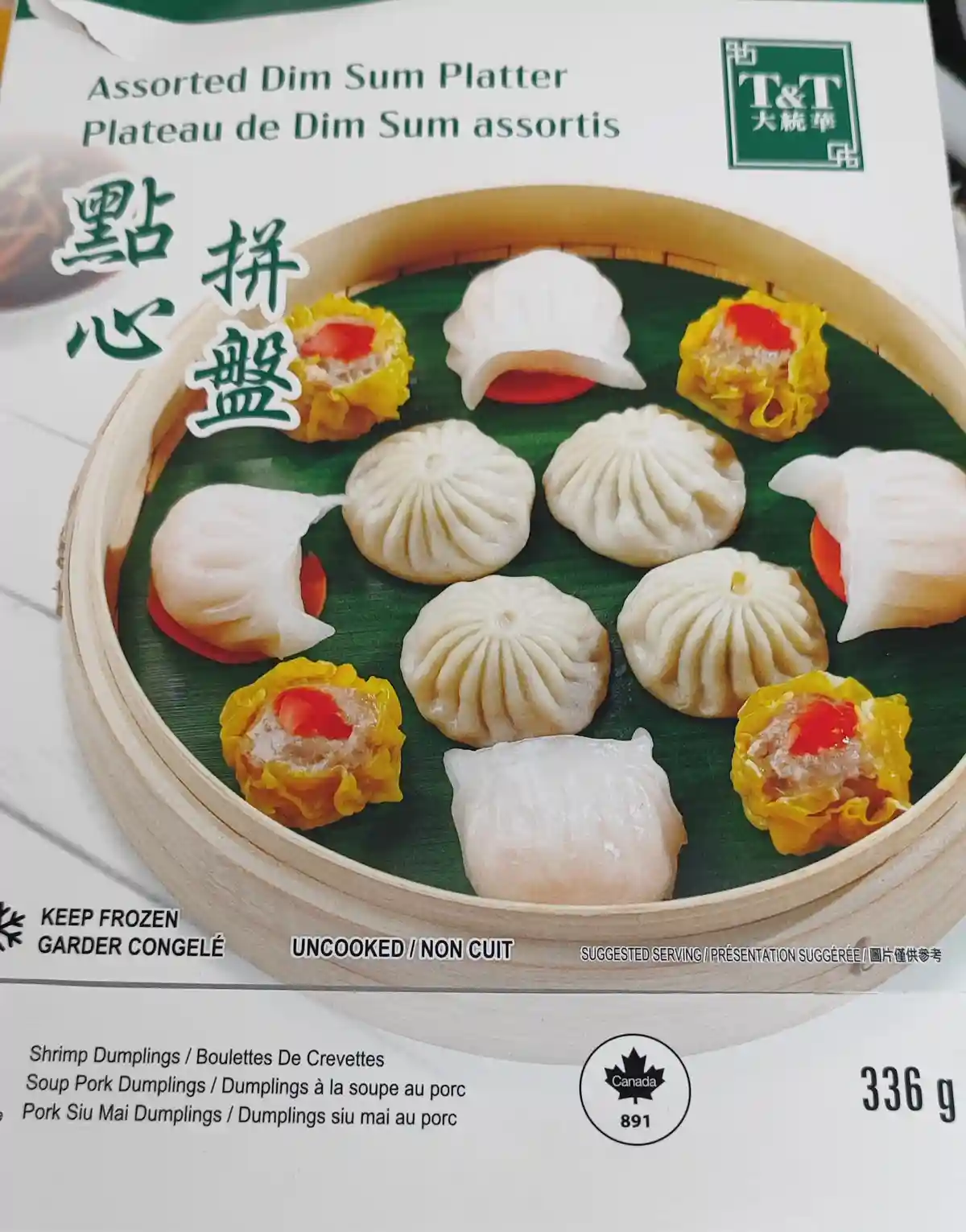 A frozen food package from T&T Supermarket shows a bamboo steamer filled with various uncooked dim sum dumplings, including…