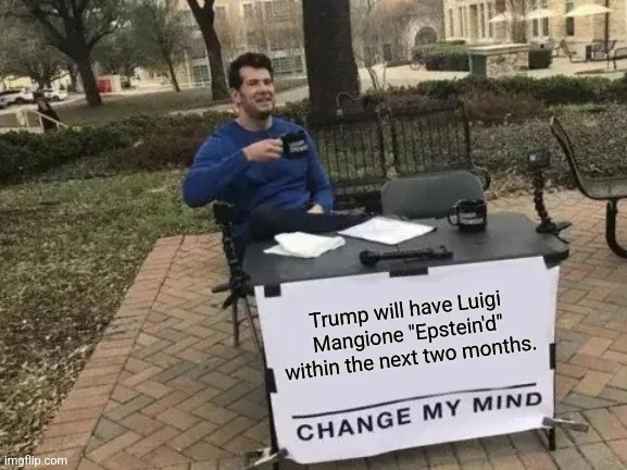 A man in a blue sweatshirt sits at a small outdoor table with a sign that reads 'Trump will have Luigi Mangione "Epstein'd"…