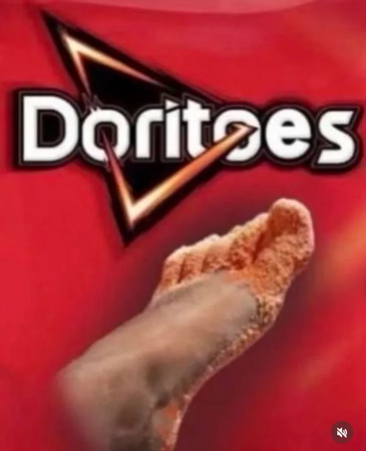 A close-up image shows a human foot covered in orange, crumbly Doritos chips, set against a red background with the Doritos…