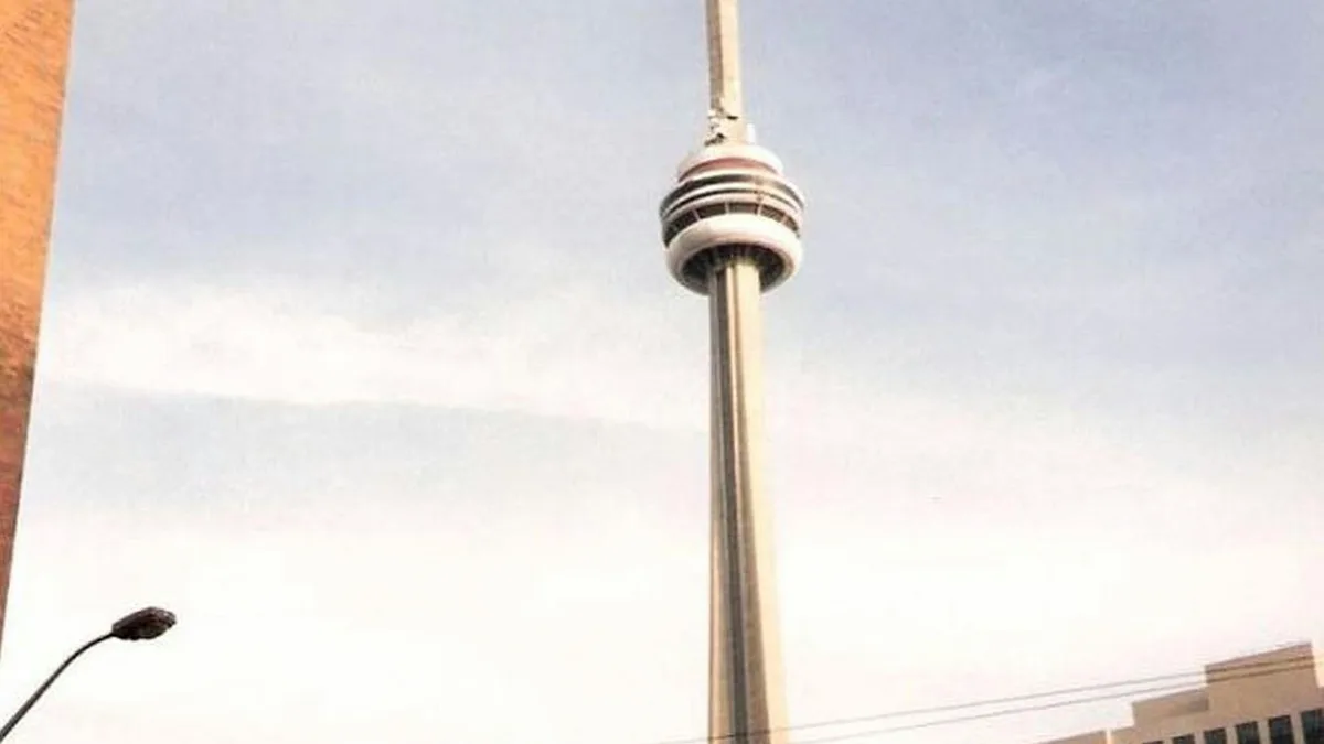 A towering giant, the CN Tower pierces the brilliant blue sky, its sleek lines and angular shape a striking contrast to the…