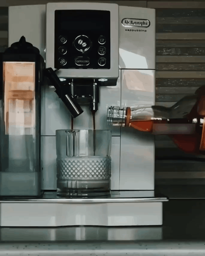 a three-panel image shows a De'Longhi coffee machine dispensing liquid into a glass while a bottle of whiskey is…