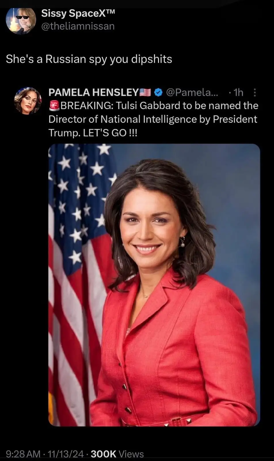 The image shows a formal portrait of Tulsi Gabbard, a woman with dark hair wearing a red blazer, smiling in front of an…