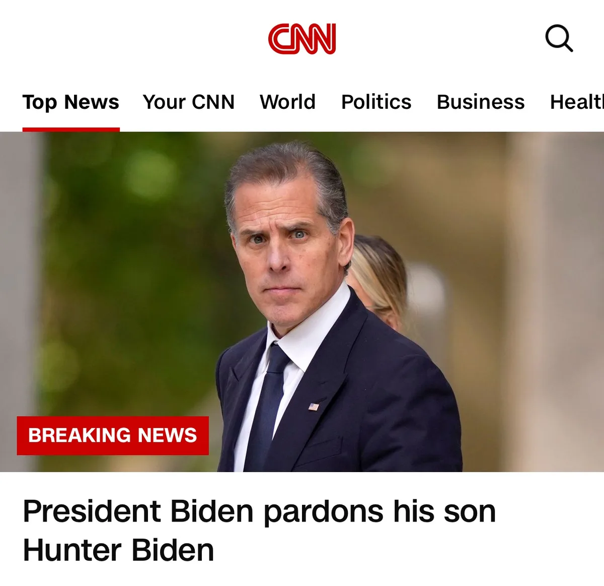 A screenshot of a CNN news page shows a man in a dark suit and tie with a serious expression, overlaid with a red 'BREAKING…