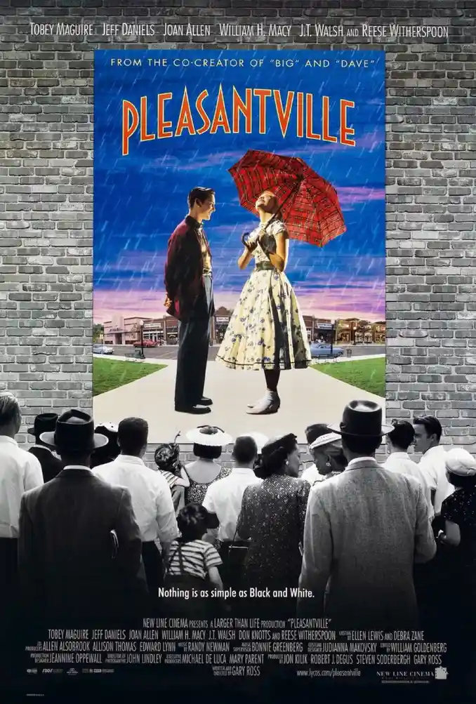 A movie poster for 'Pleasantville' is mounted on a brick wall, showing a colorful scene of a man and woman under a red…