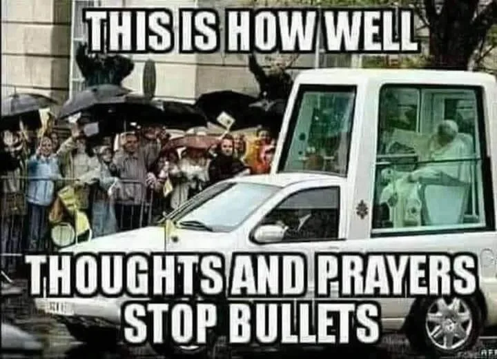A white armored vehicle, resembling a popemobile, is shown with a crowd of people holding umbrellas behind a barrier. The…