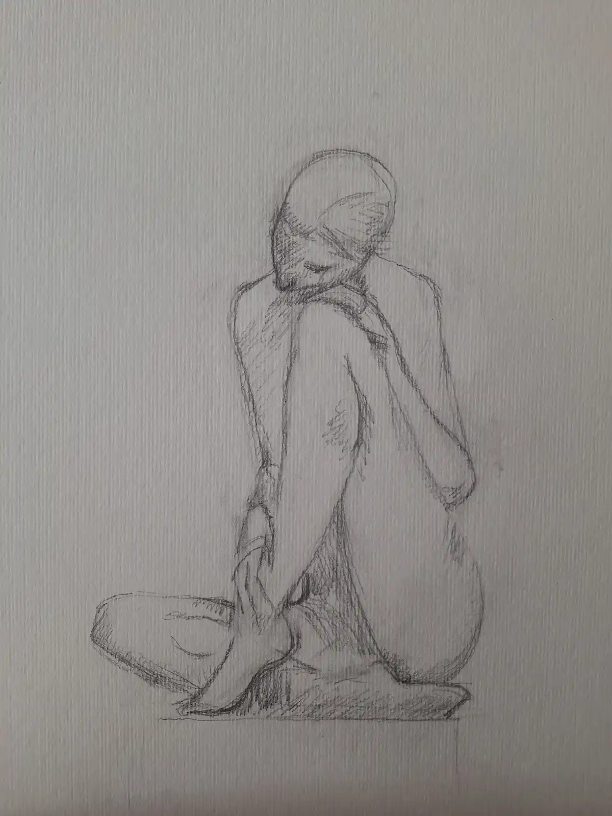 A rough pencil sketch depicts a person sitting on the floor with their head bowed and arms wrapped around their knees…