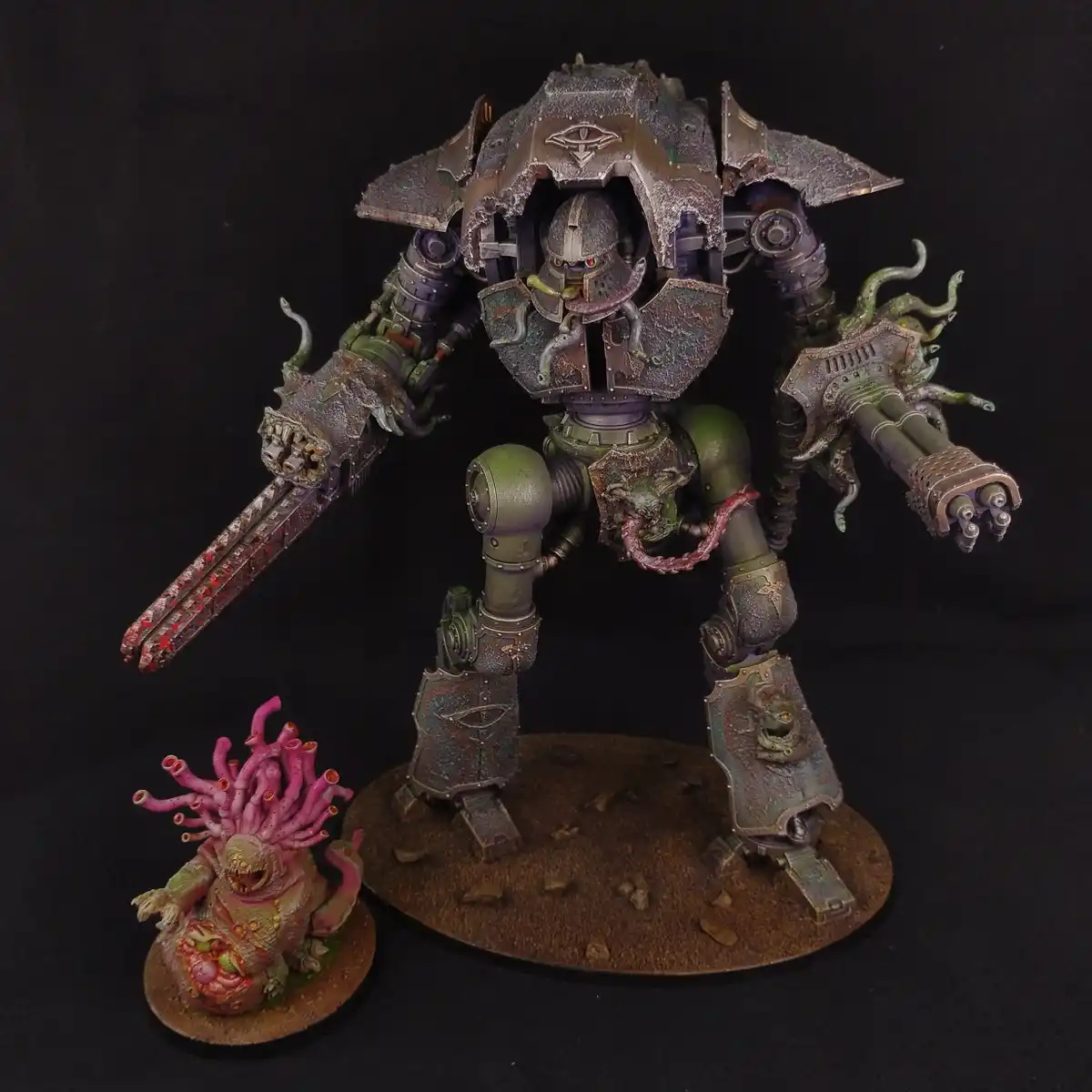 A heavily weathered, green and brown painted giant war machine stands on a circular base, its armor cracked and adorned with…