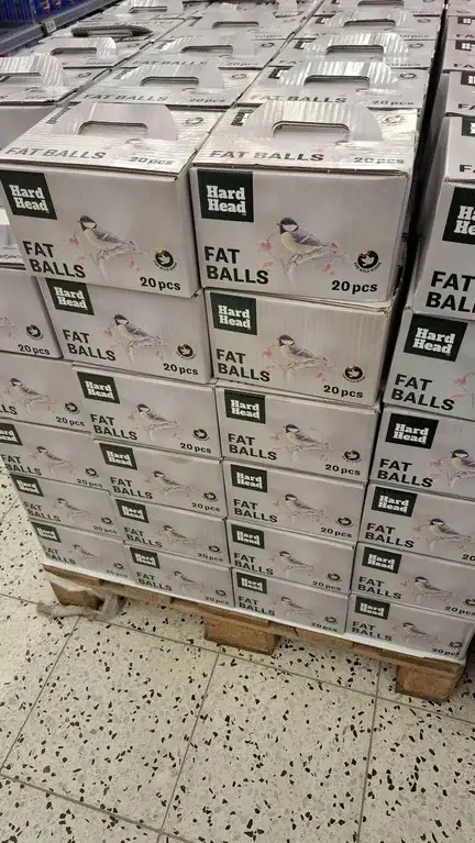 A large pallet stacked high with identical white boxes labeled 'Hard Head FAT BALLS 20pcs', each featuring an image of a…