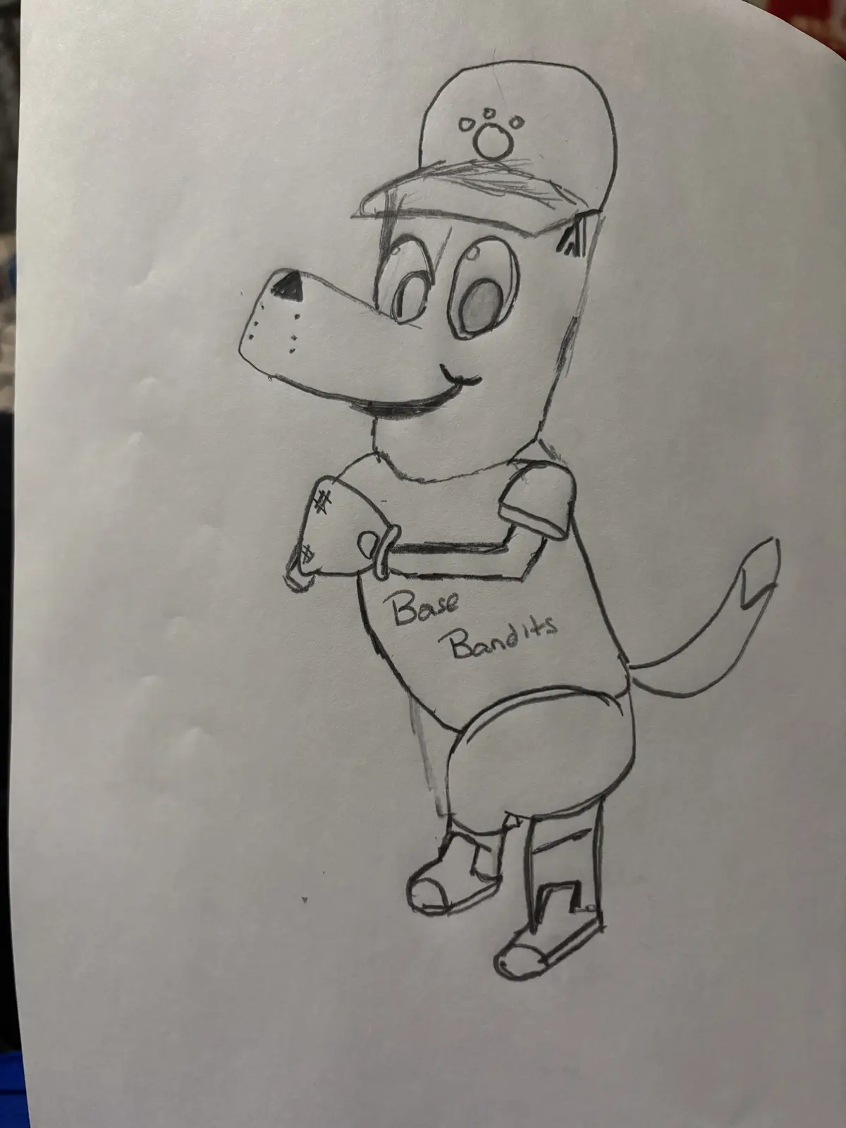A hand-drawn pencil sketch of a cartoon dog wearing a baseball cap with a paw print, a t-shirt with the words 'Base Bandits'…