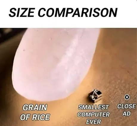 A close-up image shows a tiny, rectangular electronic device labeled 'SMALLEST COMPUTER EVER' placed beside a grain of rice…