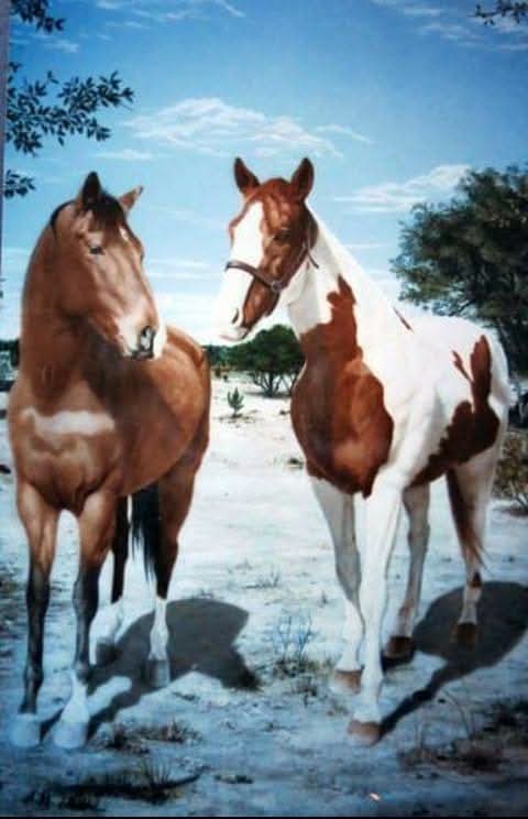 A painting depicts two horses standing in a sandy, tree-dotted landscape under a blue sky. The horse on the left is solid…
