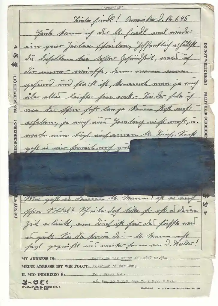 A vintage World War II-era prisoner of war letter form with handwritten German text, partially obscured by a large blue ink…