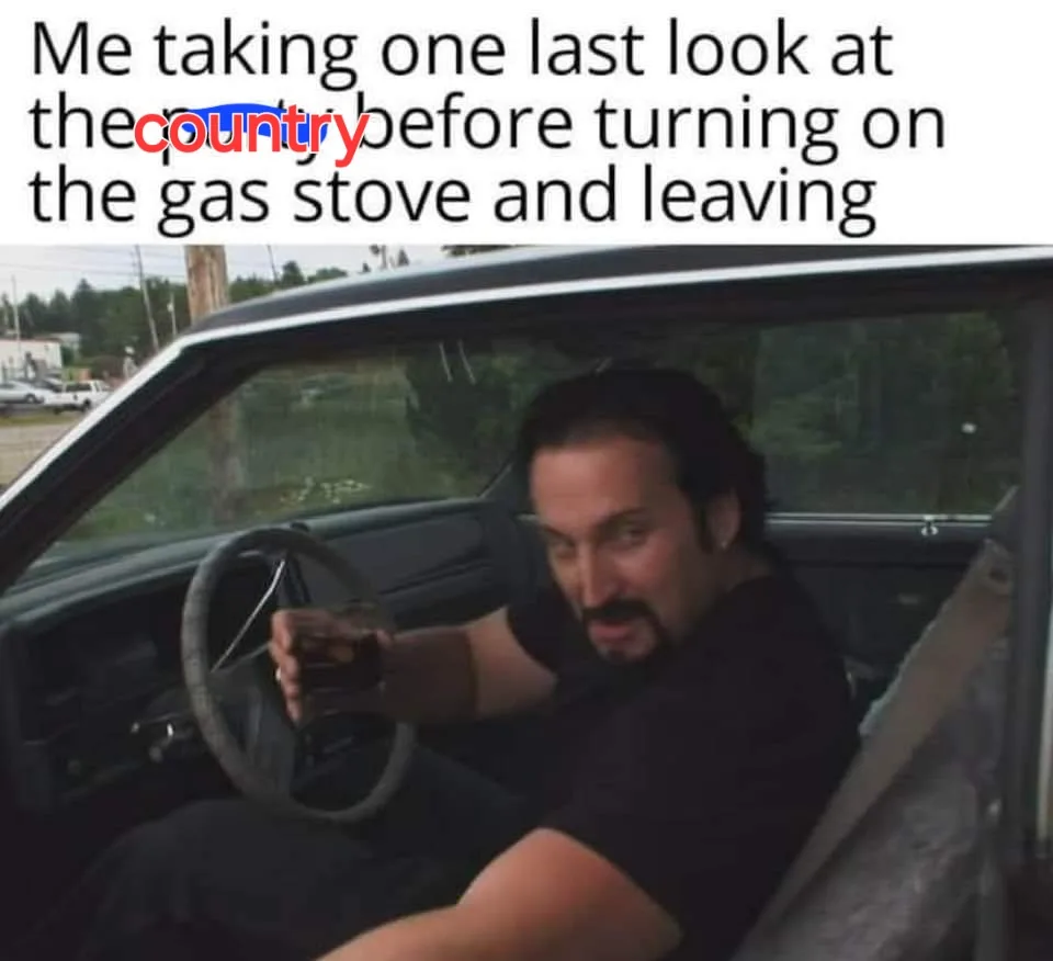 A man sits in the driver's seat of a car, holding a drink, looking back over his shoulder with a resigned or slightly amused…