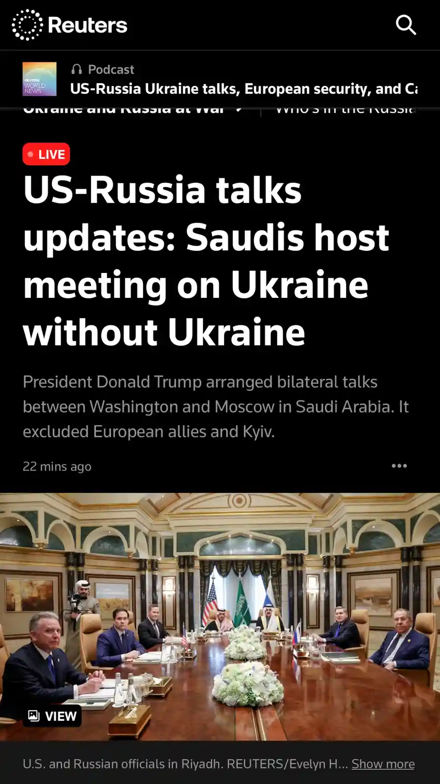 A Reuters news screenshot shows a formal meeting of U.S. and Russian officials seated at a long wooden table in a grand room…
