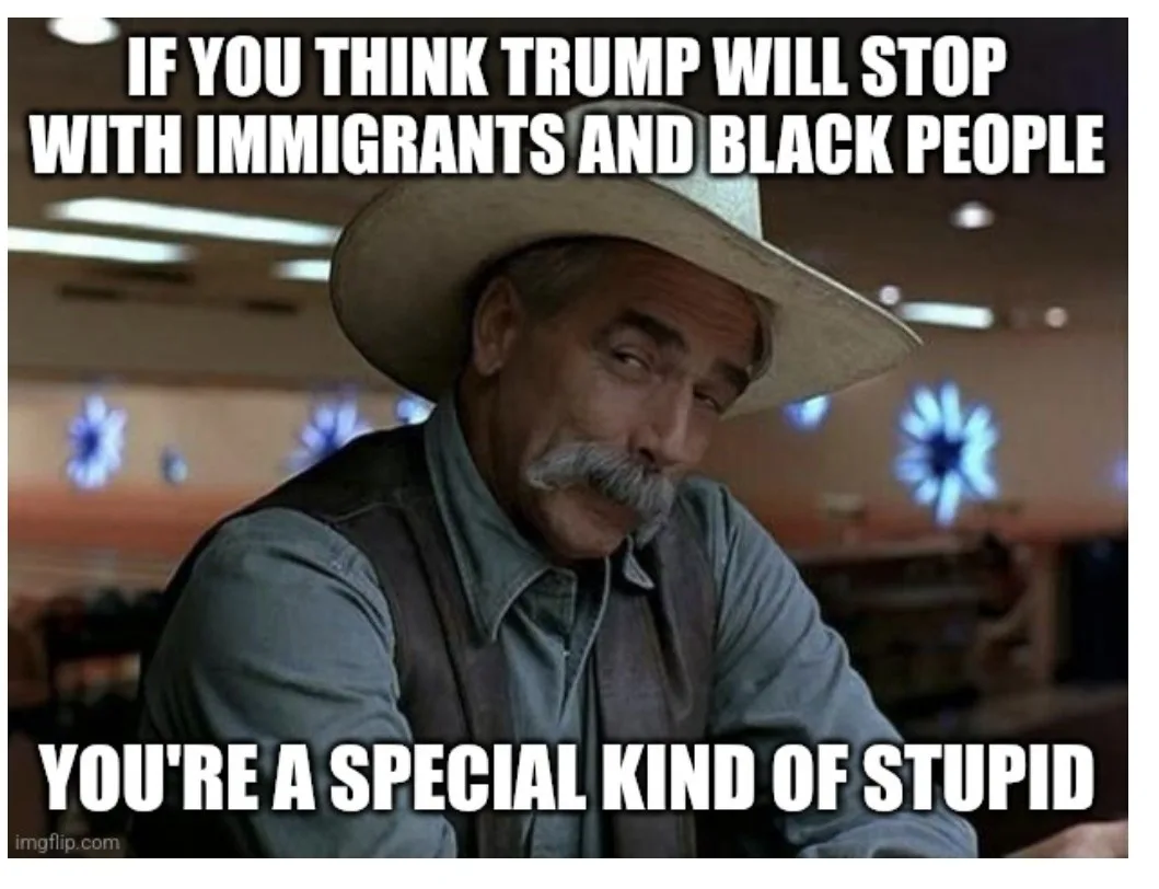 A man with a mustache and cowboy hat looks directly at the viewer with a skeptical, disapproving expression. The image has…