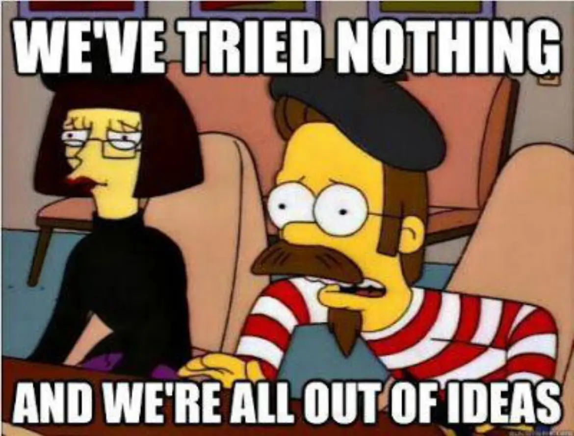 The image shows two characters from The Simpsons: a woman with dark bobbed hair and glasses wearing a black top, and a man…
