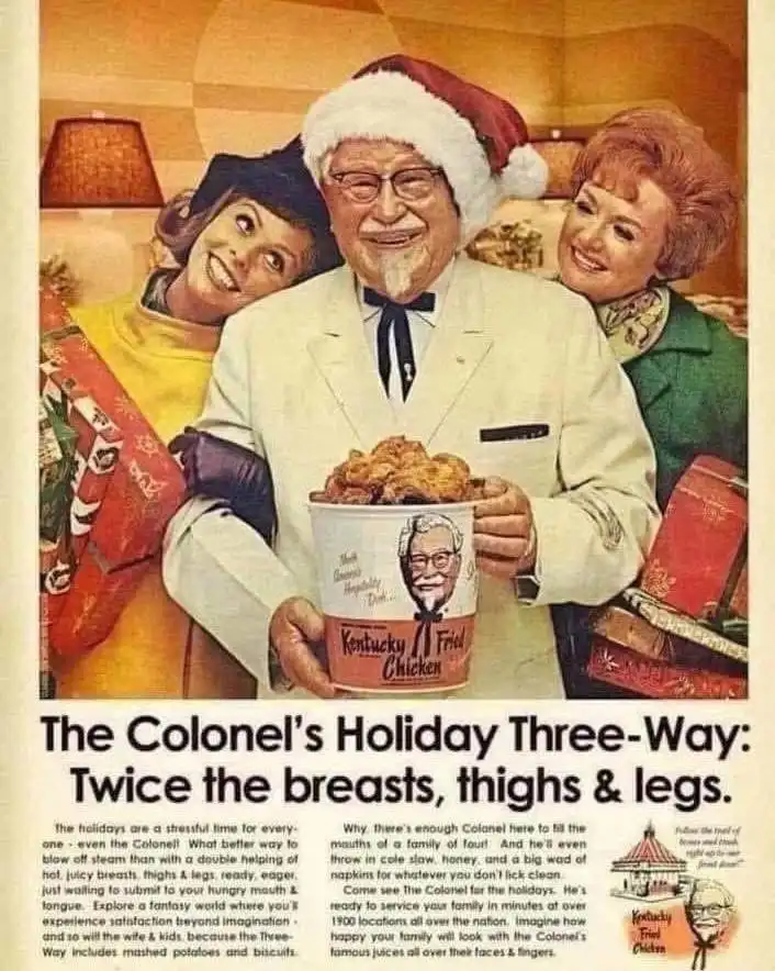An old Kentucky Fried Chicken advertisement featuring Colonel Harland Sanders in a Santa hat holding a bucket of fried…