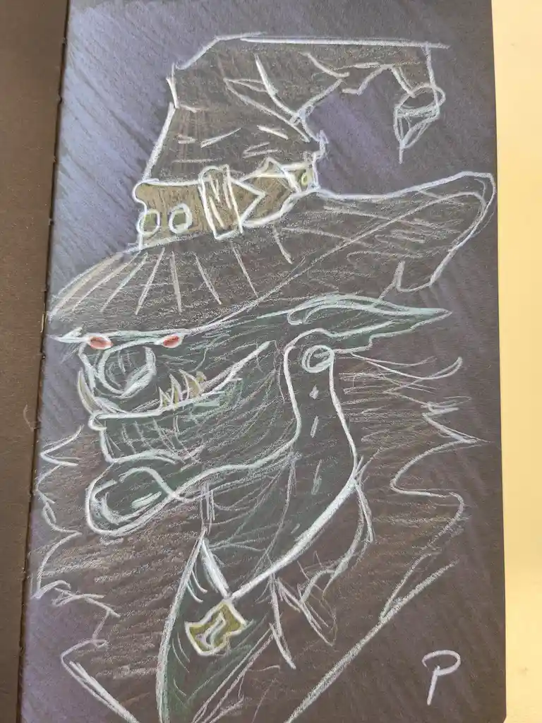 A chalk drawing on brown paper depicts a green, monstrous creature with sharp teeth, glowing red eyes, and a large, ornate…
