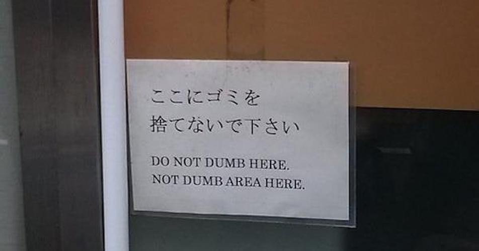 A sign in Japanese and English is affixed to a glass door or window. The Japanese text reads 'ここにゴミを捨てないで下さい' (Please do not…