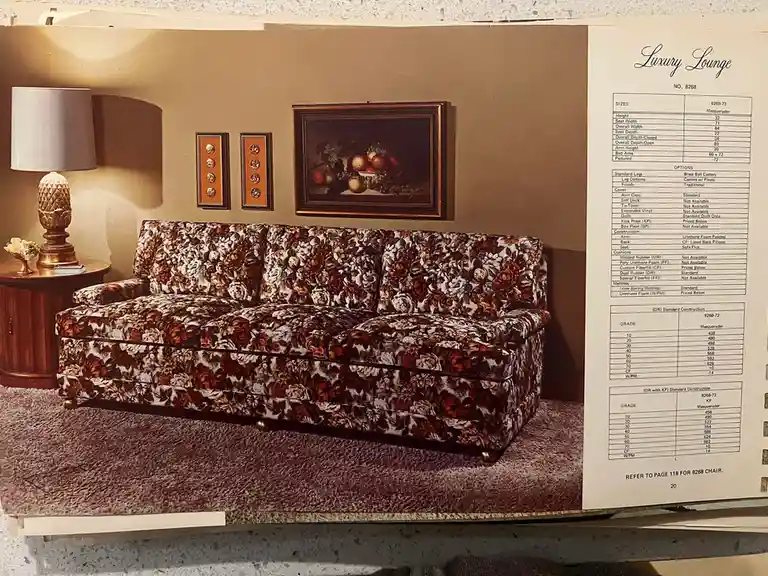 A vintage furniture catalog page displays a floral-patterned sofa in a staged living room with a lamp and fruit painting…