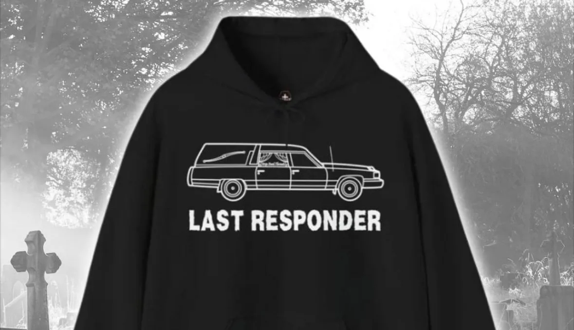 A black hoodie with a white outline of a hearse and the text 'LAST RESPONDER' is displayed against a spooky, grayscale…