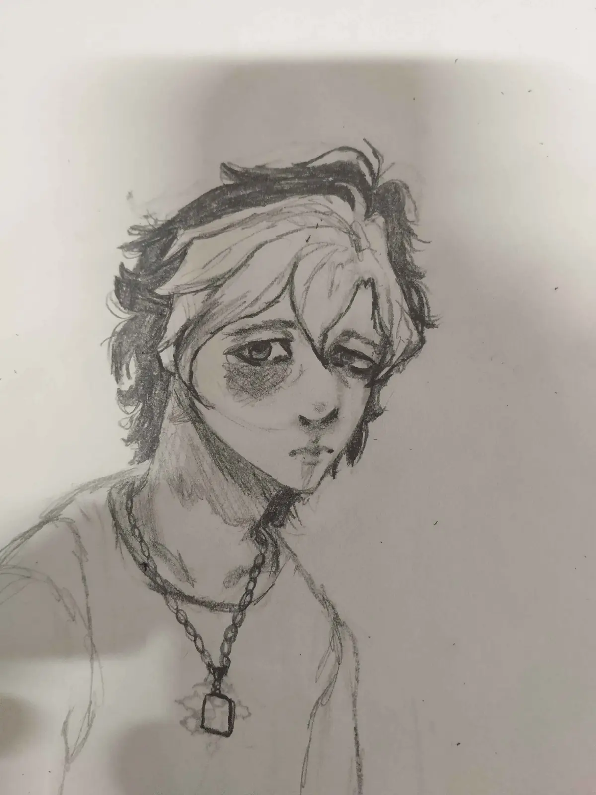 A pencil sketch of a person with messy hair, dark circles under their eyes, and a chain necklace with a square pendant…