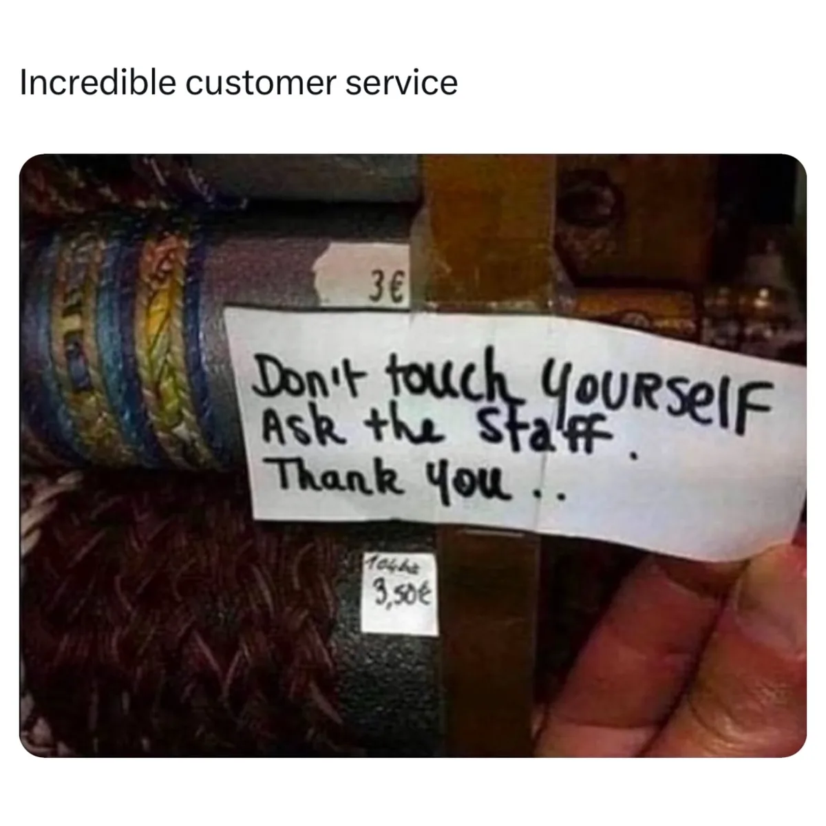A close-up photo shows a hand holding a handwritten note taped to a display of yarn or fabric rolls. The note reads: 'Don't…