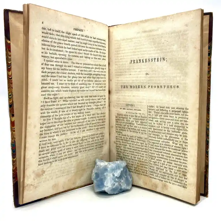 An open, aged book displaying the title page of Mary Shelley's 'Frankenstein; or, The Modern Prometheus' with visible text…