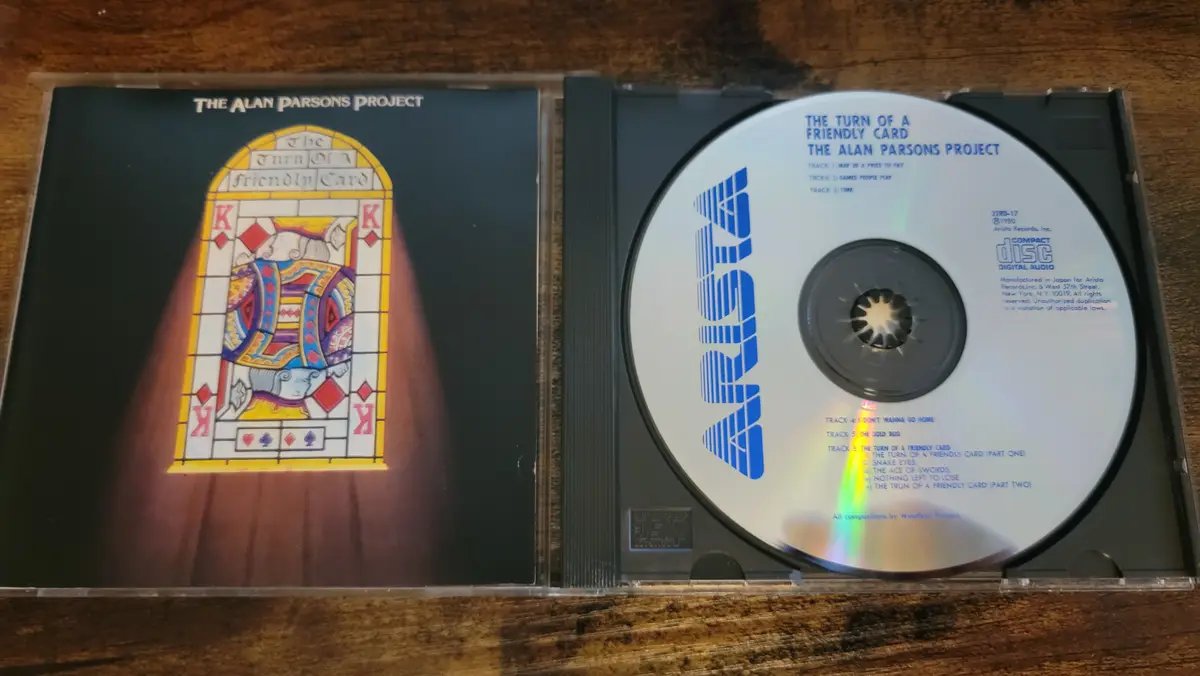 An open CD case displays The Alan Parsons Project's album 'The Turn of a Friendly Card'. The left side shows the album cover…