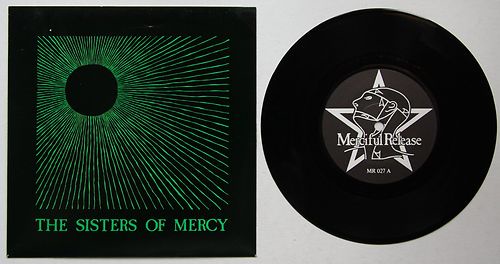 A black vinyl record and its square album cover are shown side by side. The cover features a green, sunburst-style graphic…