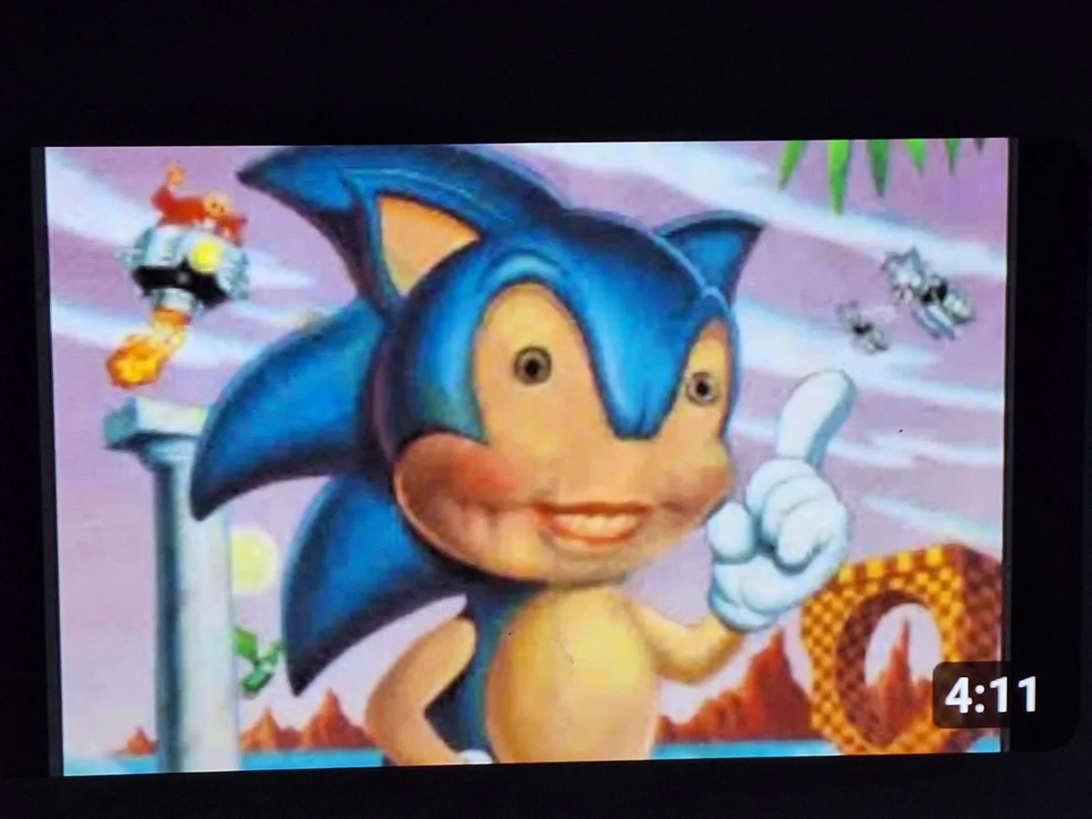 A screenshot from a video game shows the character Sonic the Hedgehog giving a thumbs-up with a cheerful expression. In the…
