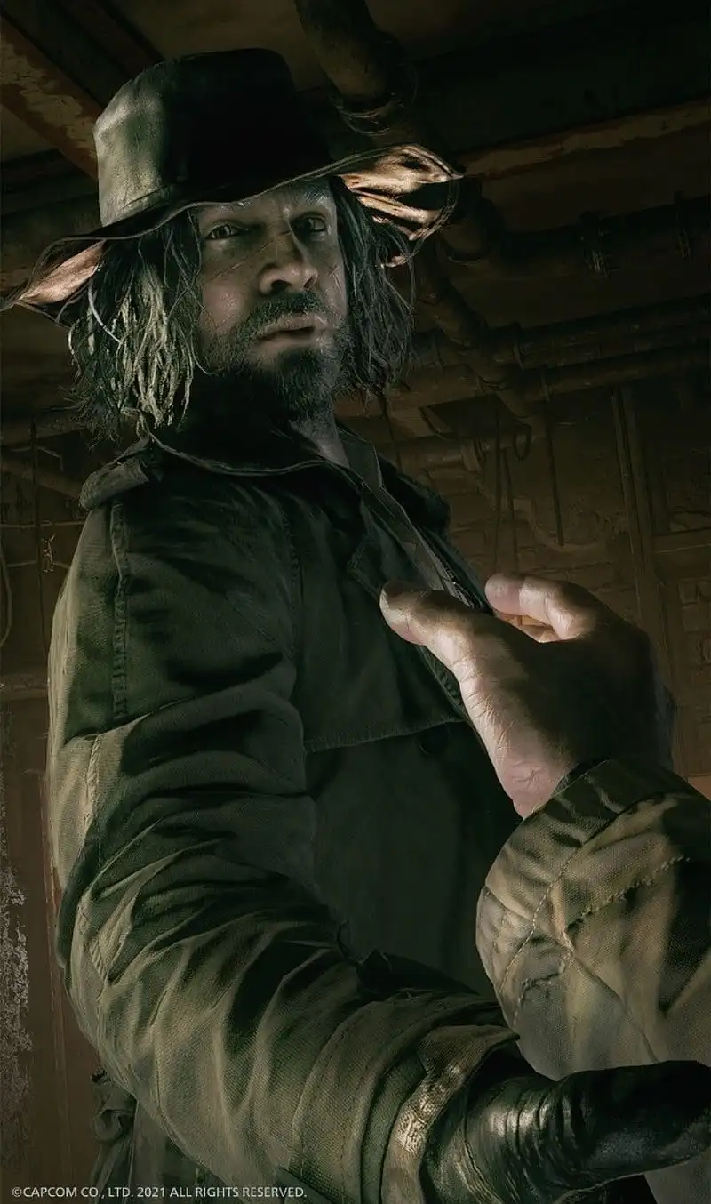 A man with long dark hair, a beard, and a wide-brimmed hat, wearing a worn jacket and gloves, looks intently at the viewer…
