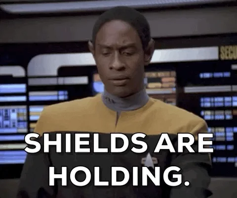 The image shows six panels of the Star Trek character Tasha Yar in a yellow uniform, repeating the phrase 'SHIELDS ARE…