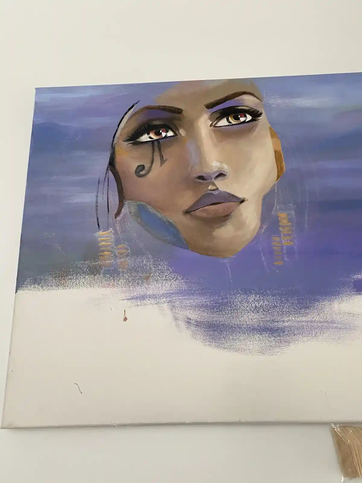A painting of a woman's face with a stylized tear falling from her left eye, set against a purple background. The artwork…