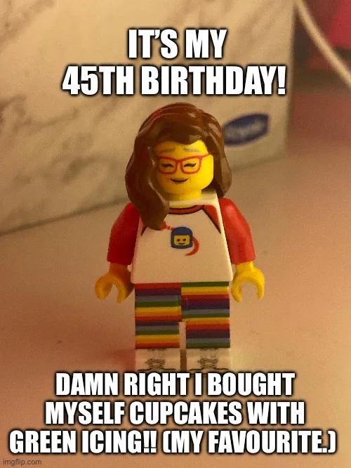A close-up photo of a female Lego minifigure with brown hair, red glasses, and a colorful striped outfit. The image has bold…