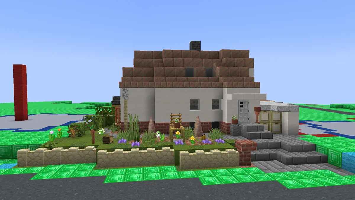 A screenshot from the game Minecraft shows a player's hand-built house with a brown roof, white walls, and a stone porch…