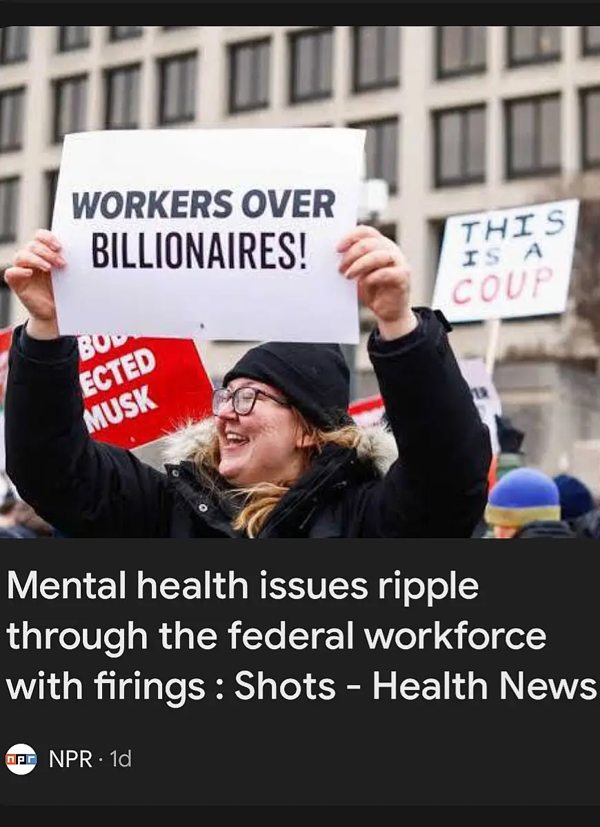 A woman at a protest holds a sign reading 'WORKERS OVER BILLIONAIRES!' while smiling broadly. Behind her, another sign reads…