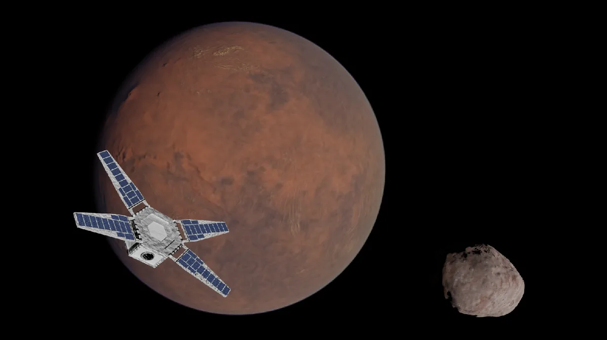 A spacecraft with solar panels orbits a large red planet, identified as Mars, while a smaller, irregularly shaped moon-like…