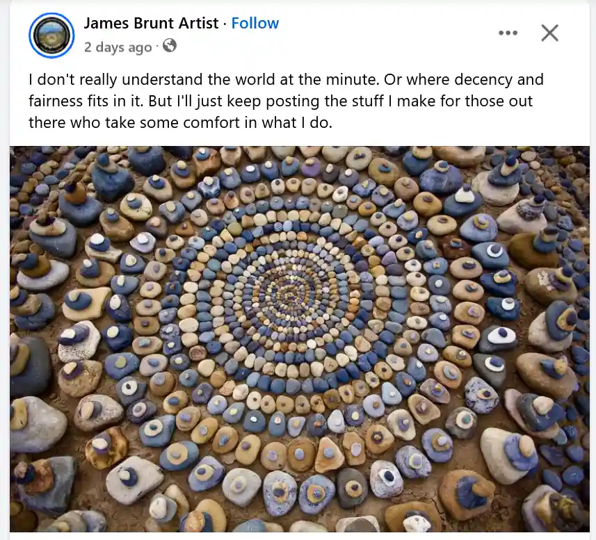 An overhead photo of a large, intricate spiral pattern made from hundreds of small, smooth stones arranged in concentric…