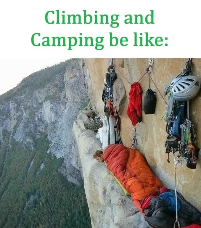 A person is sleeping in an orange sleeping bag, suspended on a narrow ledge of a steep cliff face, with climbing gear like a…