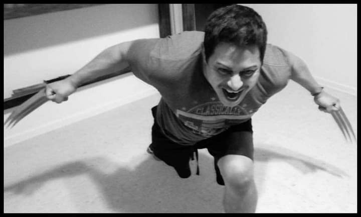 A black-and-white photo shows a man in a crouched, aggressive pose, wearing a t-shirt and shorts, with homemade…