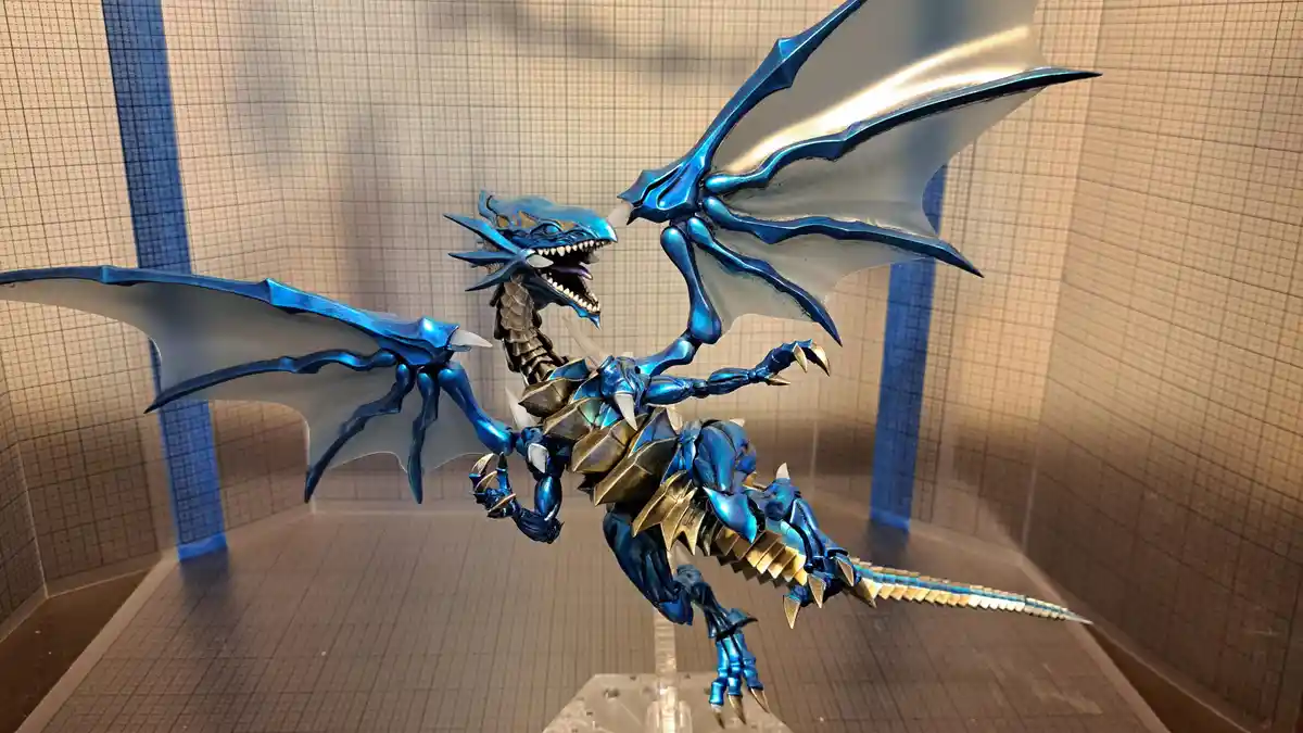 A highly detailed, metallic blue dragon figurine with gold accents, large wings, and sharp claws is posed dynamically inside…