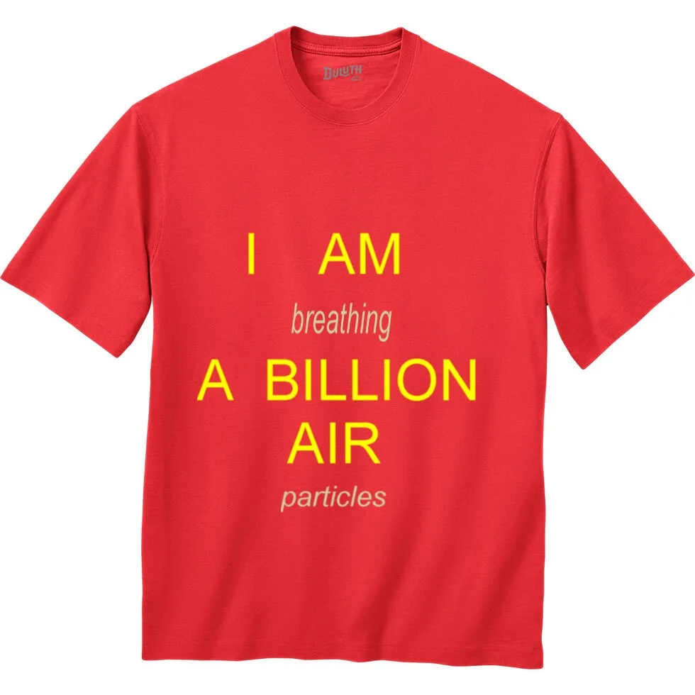 A plain red t-shirt with bold yellow text that reads 'I AM breathing A BILLION AIR particles', with 'breathing' and…