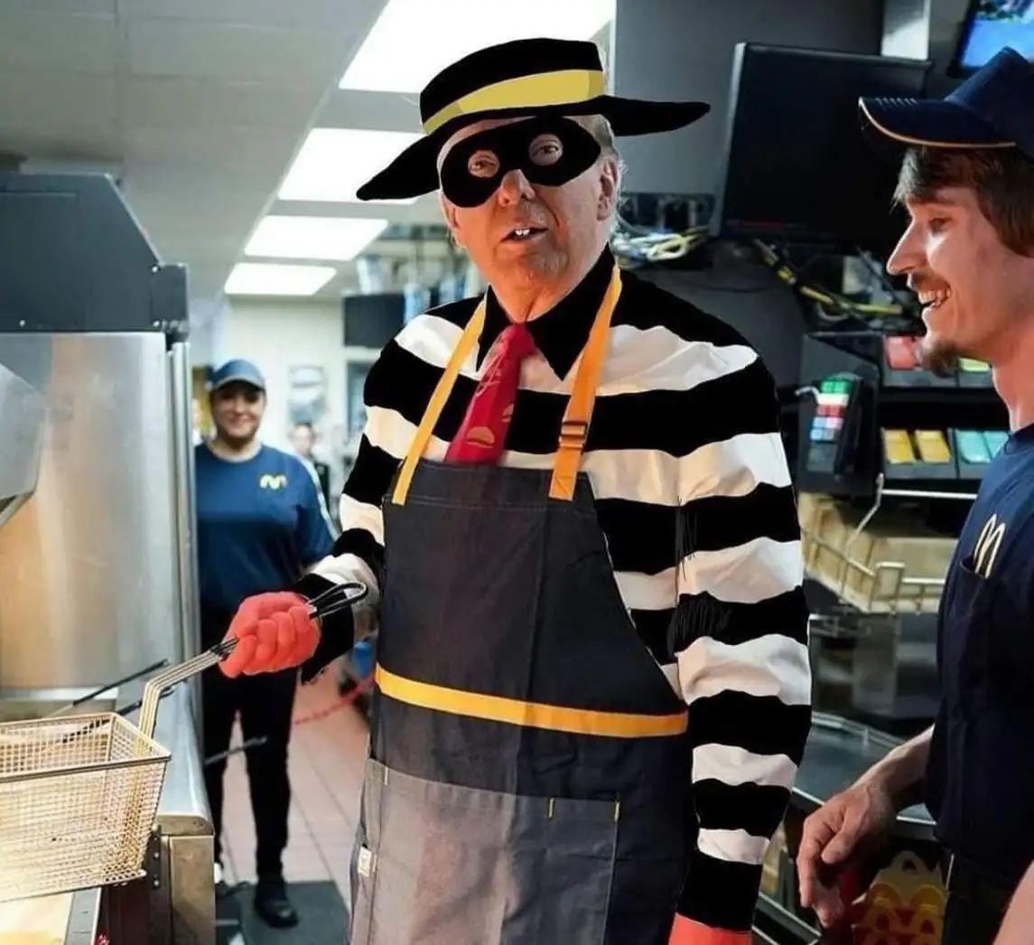 A man in a McDonald's uniform, wearing a black-and-white striped shirt, a black mask, a black hat with a yellow band, and a…