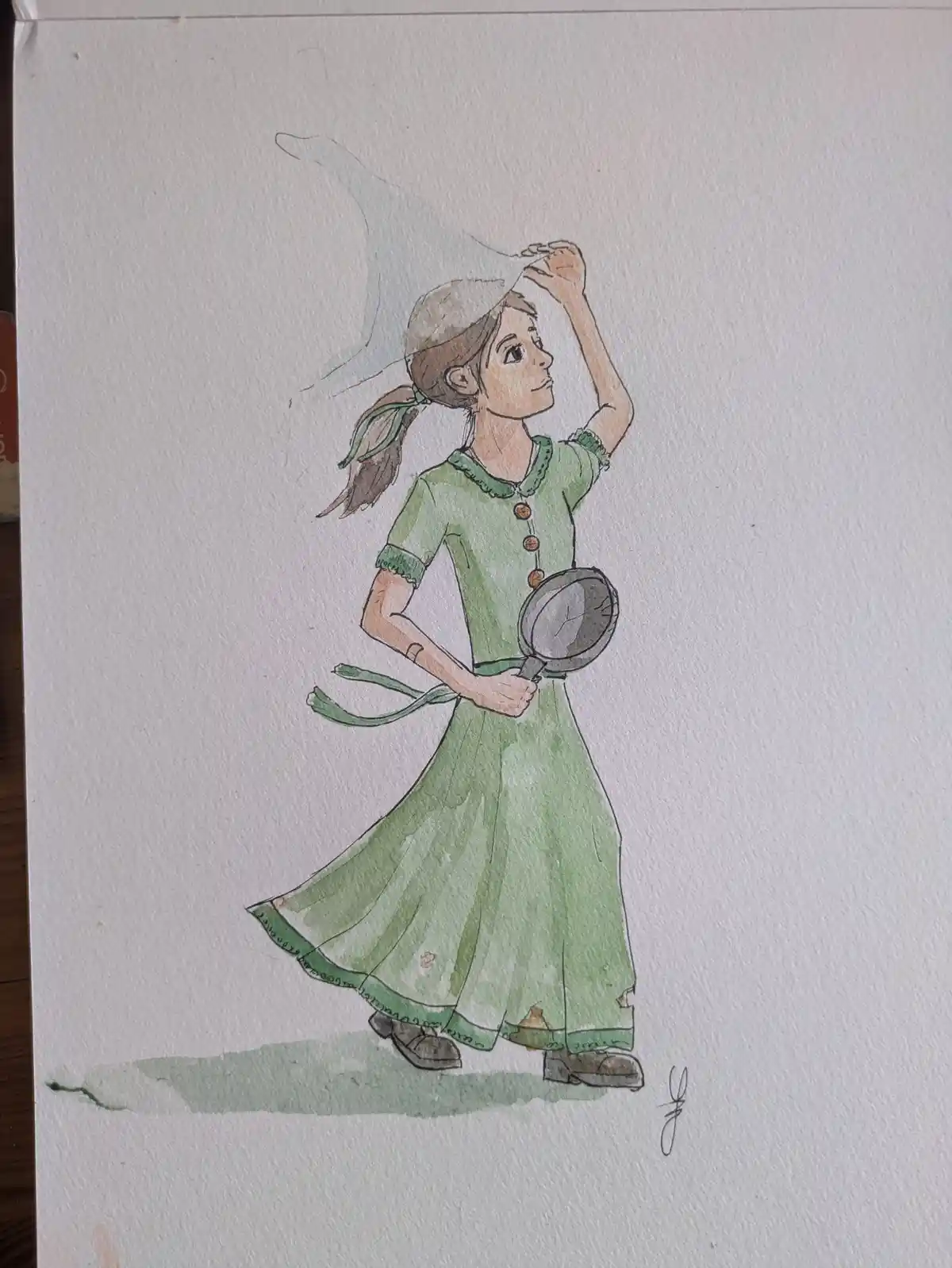 A watercolor drawing shows a girl in a green dress holding a frying pan, adjusting a hat while a ghostly figure appears…